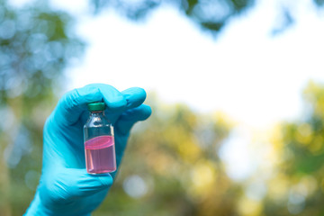 Hand holding chemistry science flask,Erlenmeyer flask over green bokeh background,concept for...