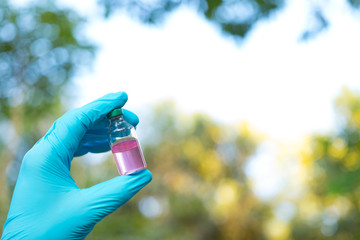 Hand holding chemistry science flask,Erlenmeyer flask over green bokeh background,concept for alternative medicine