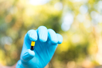 Hand holding chemistry science flask,Erlenmeyer flask over green bokeh background,concept for alternative medicine