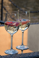 Zwei Gläser Champagner mit Erdbeeren, serviert am Wasser