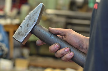 A dirty hand holds a hammer