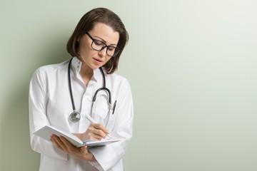 Fototapeta premium Smiling medical doctor taking notes
