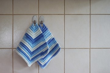 Selbstgestrickte Topflappen an der Wand hängend
