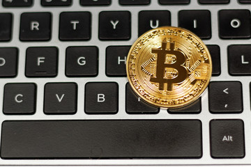 Golden bitcoin on the computer keyboard