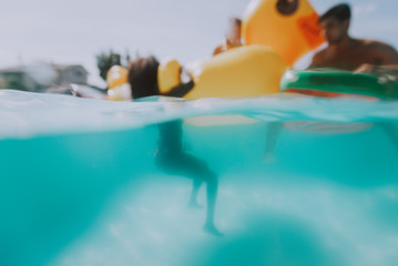 Blurred concept of friends having fun underwater in the swimming pool