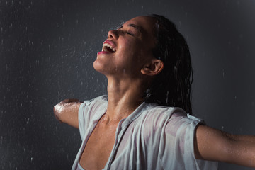Woman feeling good and free under the summer rain