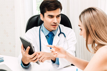 Doctor discussing and consulting with female patien on doctors table in hospital.healthcare and medicine