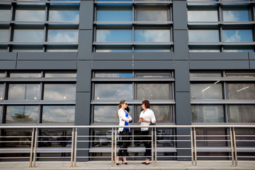 Business people standing near the modern facade background