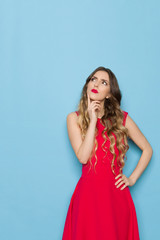 Beautiful Young Woman In Red Dress Is Looking Up And Thinking