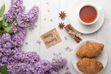 Lilac with croissants and tea on a light background