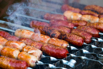 Close up of  grilling sausages on bbq on warm summer day