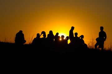 Fototapeta na wymiar People silhouettes against the sunset