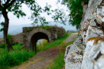 Sentiero di campagna lungo le mura di un castello, con ponte romano in lontananza - obrazy, fototapety, plakaty