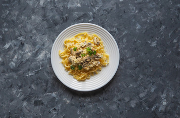 Pasta with mushrooms on a gray background. Copy space for your text.
