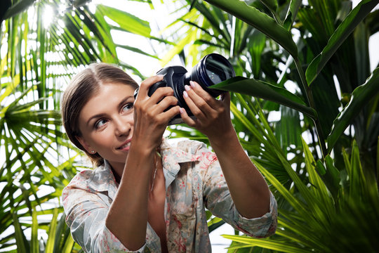 portrait of nice young woman is taking picture in the  jungle