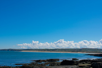 landscape over beach, water and coast of northern Ireland clear blue sky 