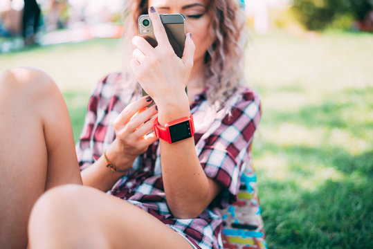 BUCHAREST, ROMANIA, - October 26, 2017: Person using smart watch and a smartphone walking on the park in a sunday. Woman making gestures on a wearable smart watch. Illustrative editorial content. - Powered by Adobe