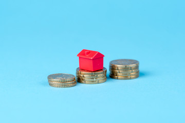 Rotes Haus mit mehreren Geldmünzen