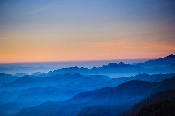 Fototapeta na wymiar Night sky before sunrise in top of view of beauty blue shade mountain range in the early morning dawn.