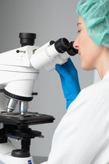 Microscope observation by young woman researcher
