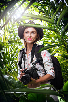 portrait of nice young woman is taking picture in the  jungle