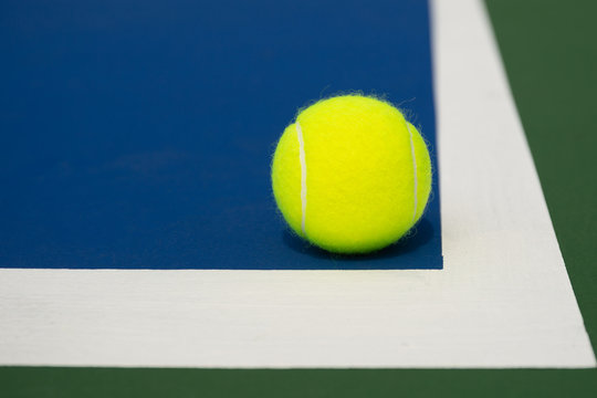 Tennis ball on a blue tennis court