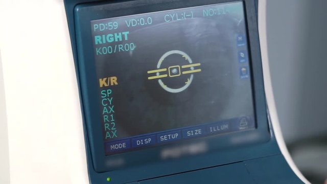 Close-up of display of auto refractometer in ophthalmological clinic. Examining of cornea and pupil for selection of contact lenses