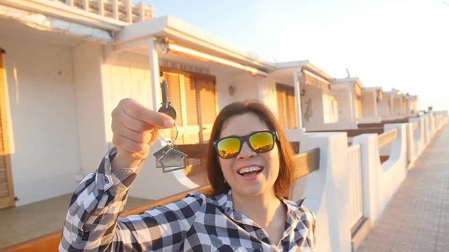 Happy young woman with New House Keys outdoors