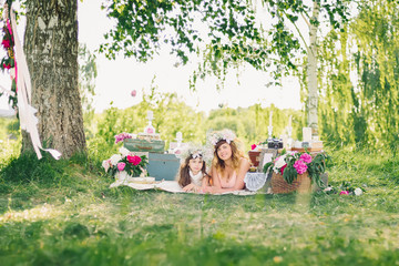 Obraz premium happy sisters lying on a blanket outdoors on a Sunny summer day