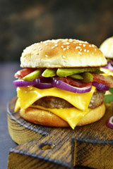 Cheeseburger with beef cutlet, fried bacon and pickled cucumber.