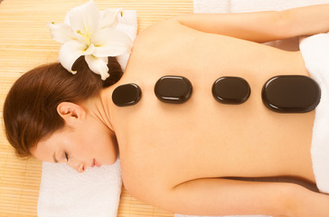 Obraz na płótnie Canvas Stone therapy. Woman getting a hot stone massage at spa salon