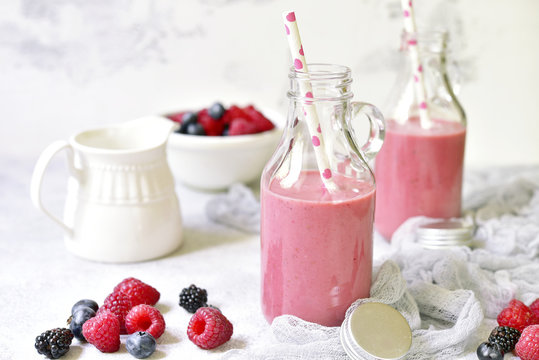 Berry smoothies in a vintage bottles with paper straws.