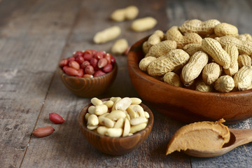 Assortment of peanut in a wooden bowls and peanut butter.