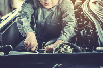 technician working on checking and service car in  workshop garage; technician repair and maintenance engine of automobile in car service