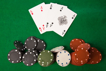 Poker chips and cards on green table