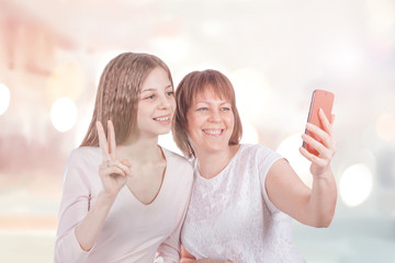 Two cheerful girlfriends do selfie with the phone