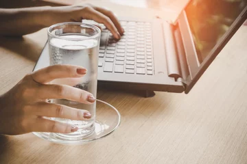 Gordijnen zakenvrouw die zoet water drinkt tijdens het werken op een computerlaptop op kantoor © doucefleur