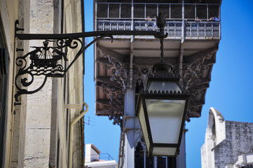 Detail lf a traditional lamp post with the Santa Justa Lift (Elevador de Santa Justa) on the background in Lisbon, Portugal.