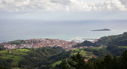 Bermeo fishing town views on cloudy day with Izaro island near the harbor, Basque Country