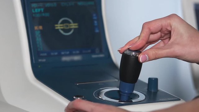 Hand of doctor and screen of medical device for examining eyes. Autorefractometry in a modern medical clinic before operating, close-up