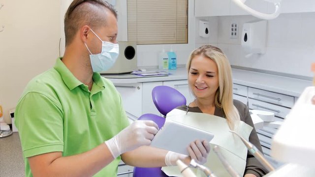 4k footage of dentist explaining teeth treatment on digital tablet
