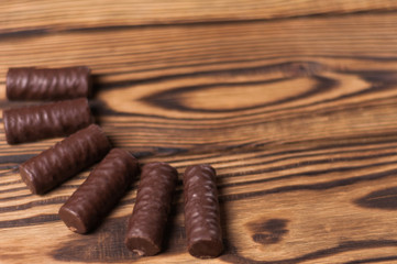 Row of yummy chocolate candies on old weathered wooden table. With copy space