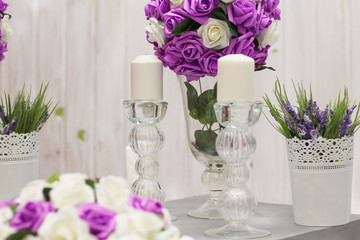 lilac flowers in a vase and candles on the candle holders for a romantic atmosphere