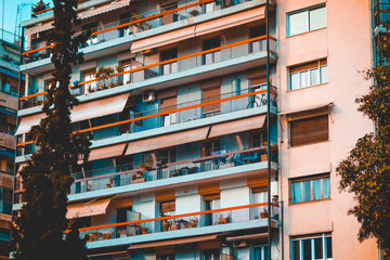 mediterranean apartment houses with balcony and big trees in the foreground