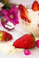 glass bowl of strawberries with cream with spring background