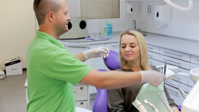 4k footage of dentist taking off surgical mask and protective tissue from patient