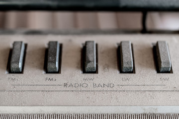 Dusty old buttons for radio band selection on a vintage tape player 