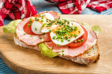 Sandwich with tomatoes, eggs and lettuce.