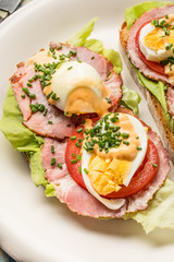 Sandwich with tomatoes, eggs and lettuce.