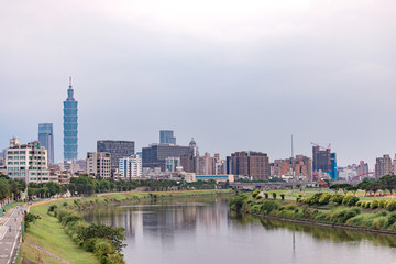 Fototapeta premium Tajpej, Tajwan - 5 maja 2018: Panorama z lotu ptaka nad centrum Tajpej z wieżowcem Taipei 101, charakterystycznymi budynkami Tajpej, rzeką Keelung, dzielnicą Xinyi i centrum miasta